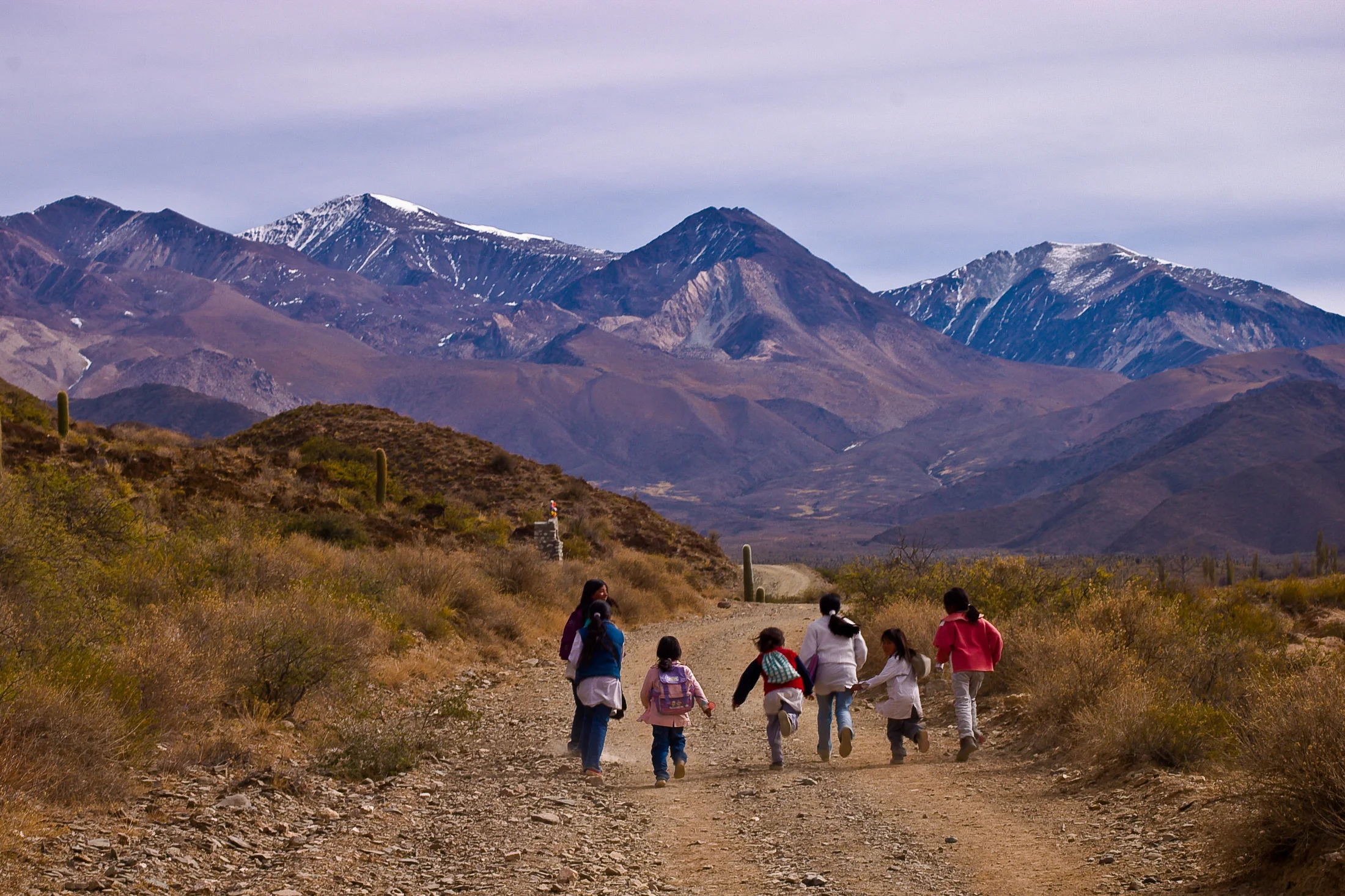 Children running along a mountain path near Cachi in Salta, Argentina