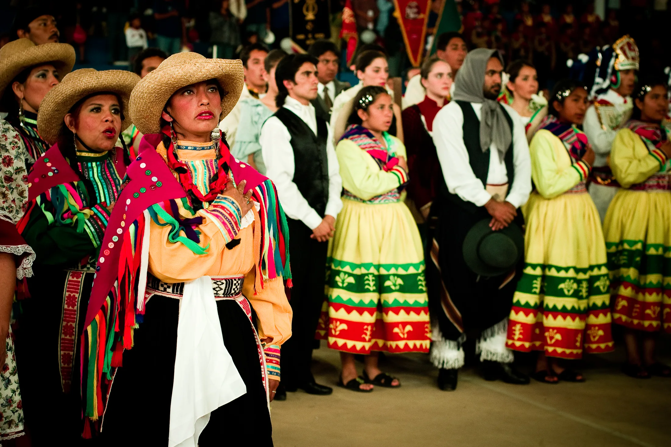 Latin American dance groups in colorful dress stand together at the festival