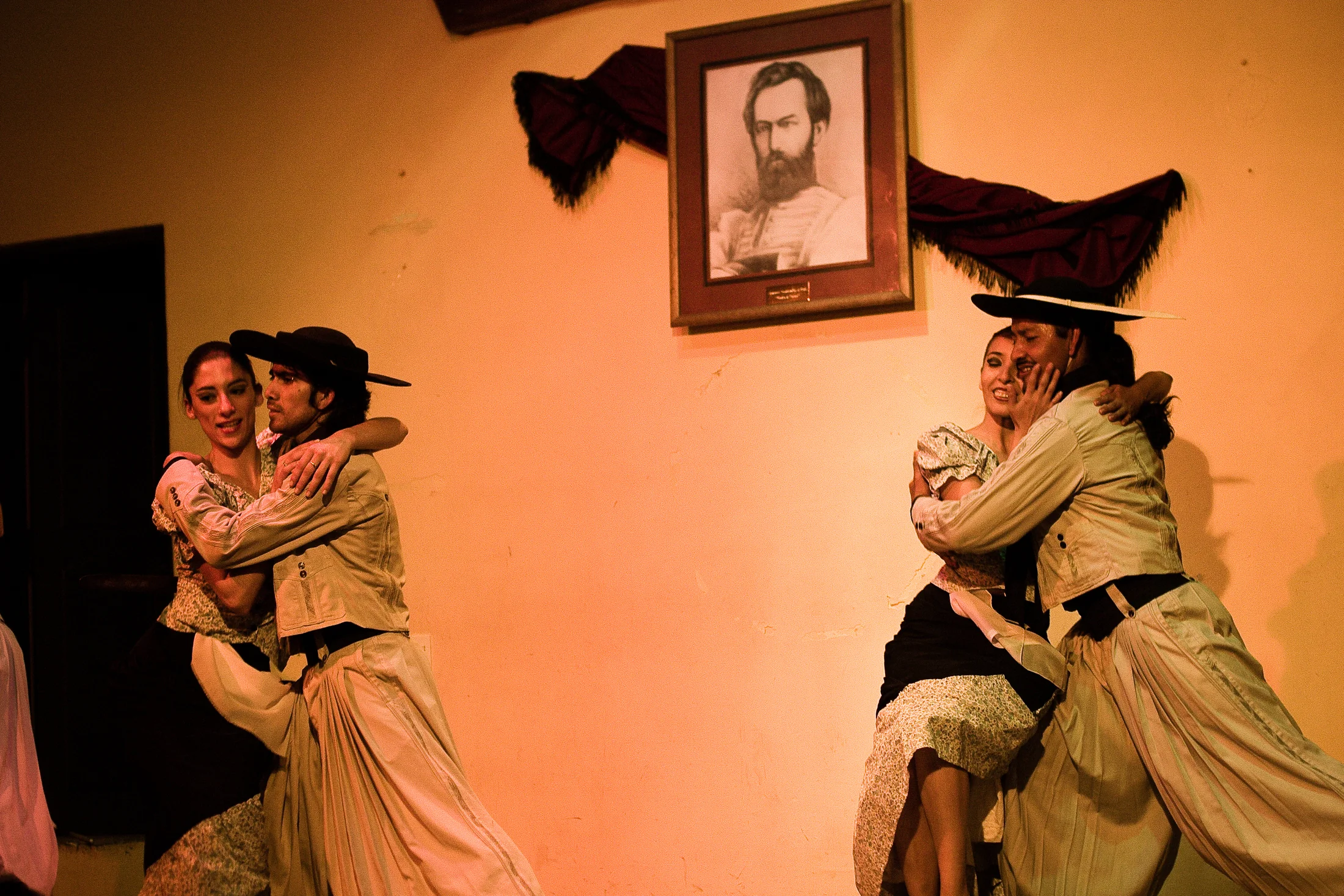 A folkloric dance couple turns together on stage in Salta